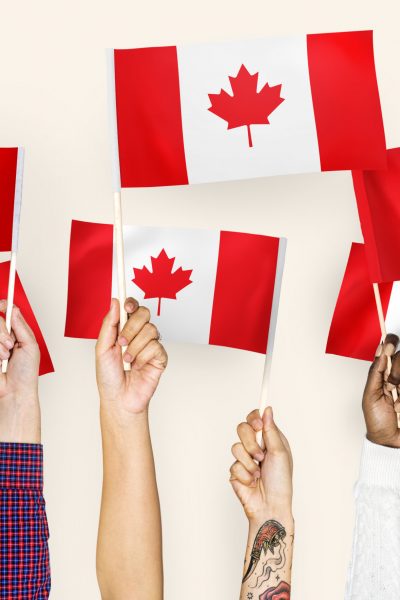 Hands waving flags of Canada
